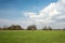 Green field, horizon and clouds in the sky