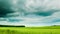 Green field with overcast clouds time lapse