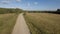 Green field. Stock footage. Huge fields with dry grass next to the road behind which you can see the city and the