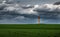 Green field, stormy sky, water tower