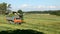 Green field in the summer of truck driving next to the combine