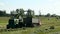 Green field in the summer of truck driving next to the combine