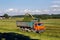 Green field in the summer of truck driving next to the combine