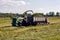 Green field in the summer of truck driving next to the combine