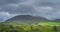 Green fields at foothill of Carrauntoohil mountain, hidden in mist or cloud