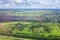 Green fields and forests, blue sky and white clouds background panoramic  aerial view, sunny summer day europe nature landscape