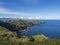 Green fields pasture and coastal cliffs and blue ocean and sky horizon at north coast of sao miguel island, Azores