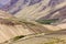 Green fields on the rocky barren brown slopes of the mountains in a Himalayan village