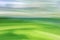 Green fields and sky. Spring summer landscape. Abstract background. The photo was taken with the movement of the camera at a long