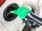 Green filling pistol stuck in the gas tank of a car at a gas station. The process of filling the car with fuel, gasoline, diesel