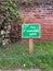 Green fire assembly point wooden sign post outside safety