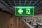 Green fire escape sign hang on the ceiling in the office