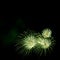 Green fireworks border on the black sky background with copyspace