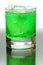 Green fizzy drink with ice cubes.