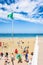 The green flag blows in the wind on the busy beach of Trestraou in Perros-Guirec, Brittany, France