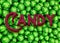 Green foil wrapped chocolate candies as a background to 3D word `Candy`