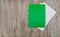 Green folder for documents and a white envelope. Wood background. Copy of space. Place for text.