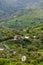 The green foot of the mountain with small houses, the countryside