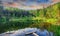 Green forest, dramatic sky, meadow and reflection in water of Cr