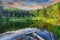 Green forest, dramatic sky, meadow and reflection in water of Cr