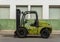 Green forklift parked on an industrial street