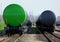 green freight train in rail yard perspective with tanker cars