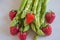 Green fresh asparagus with a bunch of healthy strawberries