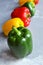 Green fresh bell pepper with multi-colored sweet peppers. Green, red and yellow vegetables. Healthy food concept