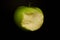 Green fresh bitten apple on a dark background