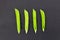 Green fresh pea pod parallel row of vegetables on a black background contrasting design set