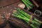 Green fresh sparrow grass on top on an antique wood chopping board on top of wooden table