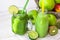 Green fruit and herbs juice in bottle, vegetable smoothie in jar mug,outdoors, summer spring sunlight spots