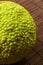 Green fruit of maclura pomifera, osage orange, horse apple, adam apple grow on bamboo mat