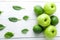 Green fruits on white wooden background. Apple, lime, spinach. Detox. Healthy food. Top view. Copy space.