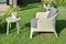 Green garden with an outdoor furniture lounge group with rattan chairs