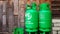 Green gas tanks on wooden wall or wallpaper with copy space on left. Group of object to make fire for cooking food
