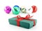 green gift box with red ribbon bow and blur group of colorful shiny christmas balls