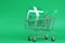 Green gift box in shooing cart on Green background object , Resource for Christmas New Year`s Day Birthday Lucky draw and Shopping