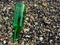 green glass bottles or beer on a pebbly beach. Top View