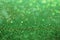 Green glitter abstract background with defocus lights