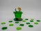 Green glittering leprechaun hat for St. Patrickâ€™s Day on a white background with little green four leaf clovers, festive for the