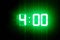 Green glowing digital clocks in the dark show 4:00 time