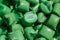 Green granules of polypropylene or polyamide on a white background. Plastics and polymers industry. Copy space. Macro