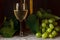 Green grapes with leaves, glass, bottle of white wine on vintage