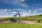 Green grass, blue sky and pumpjack