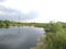 Green grass and blue sky in spring. black lake