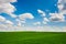 Green grass and blue sky with white clouds