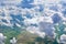 Green grass fields, forests, blue sky and white cumulus fluffy clouds background panoramic aerial view, sunny summer landscape