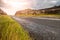 Green grass in focus, Small narrow asphalt road and rock terrain out of focus. Burren area, West coast of Ireland. Warm sunny day