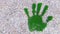 Green grass handprint on gravel background